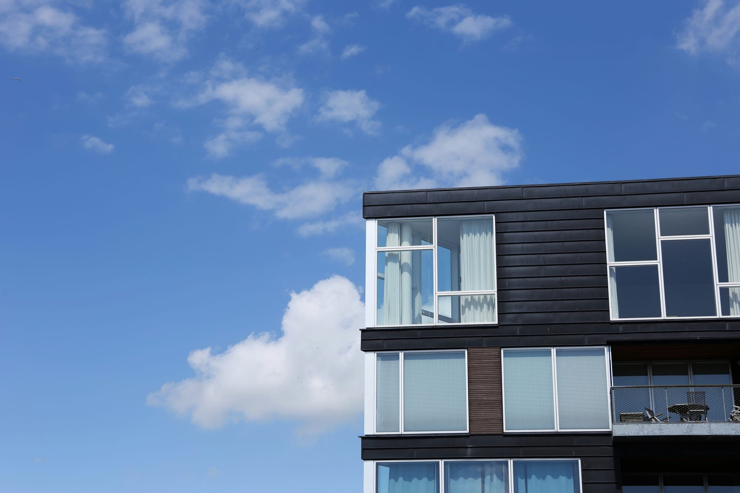 Résidence contemporaine avec fenêtres blanches sur fond de ciel bleu